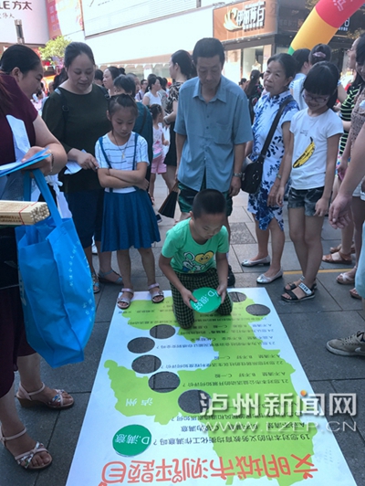 市民在宣傳點(diǎn)參加創(chuàng)文趣味游戲。 記者 朱虹 攝